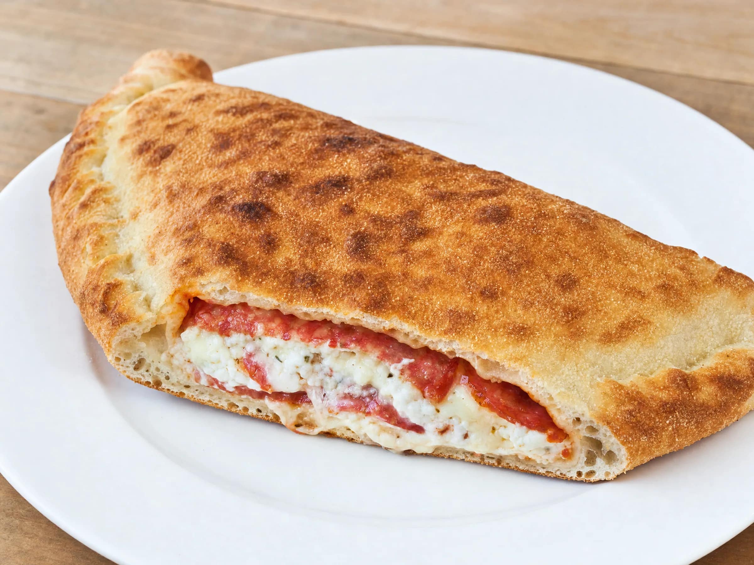 Calzone aus dem Ofen mit Tipo-00-Teig und Ricotta-Salami-Füllung