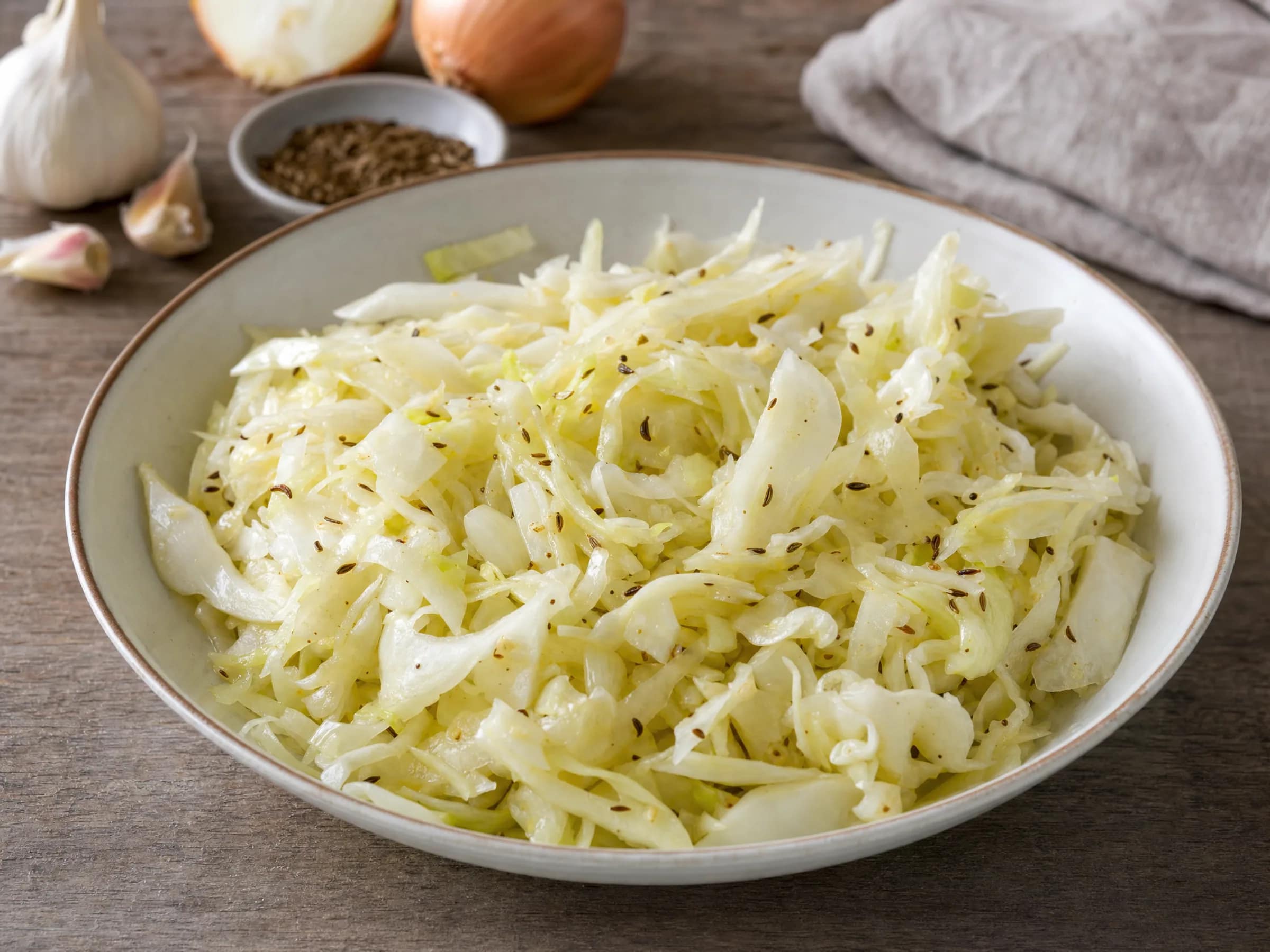 Krautsalat bayrisch – fein gehobelt mit warmem Kümmel-Dressing Rezeptfoto Krautsalat bayrisch – fein gehobelt mit warmem Kümmel-Dressing fertig angerichtet