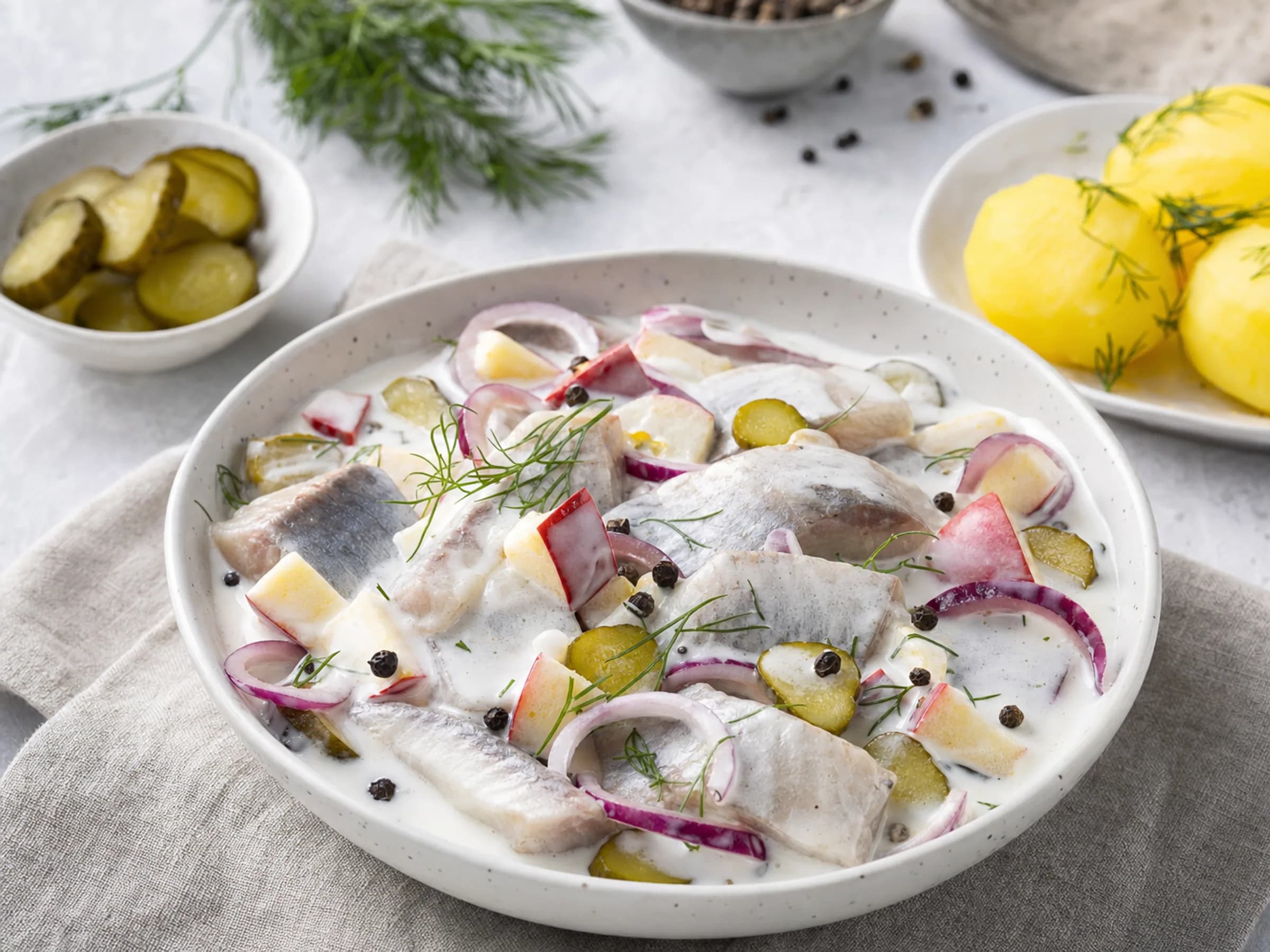 Marinierter Hering nach Hausfrauenart mit Pellkartoffeln Marinierter Hering in cremiger Sauce mit Apfel, roten Zwiebeln, Gewürzgurken, Dill und Pellkartoffeln